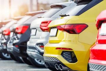 Back view many modern new multicolored SUV cars fleet stock dealership parking lot. Automobile market production factory industry warehouse. Auto salvage buy and sell auction purchase seller platform