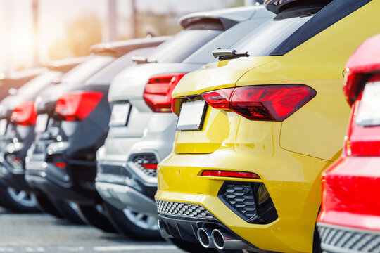 Back view many modern new multicolored SUV cars fleet stock dealership parking lot. Automobile market production factory industry warehouse. Auto salvage buy and sell auction purchase seller platform