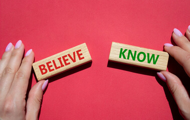 Believe or Know symbol. Concept word Believe or Know on wooden blocks. Businessman hand. Beautiful red background. Business and Believe or Know concept. Copy space