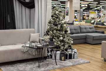 Christmas decoration of a furniture store. Store decoration for the holiday. Sofa shop. Sofa, rug, curtains and Christmas tree