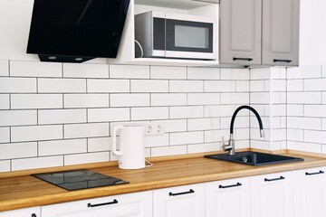 White cabinets with wooden counter of modern kitchen. High quality photo