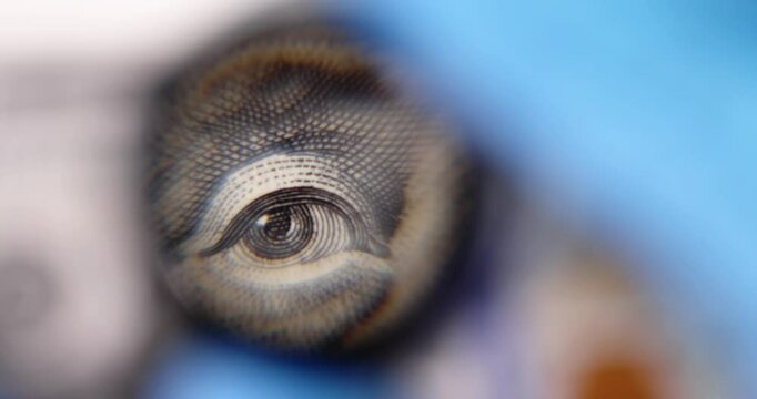 Dollar banknote undergoes detailed analysis with magnifying glass. Currency examination procedure to evaluate legitimacy of foreign money