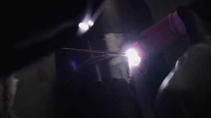 Close-up view of Gas Tungsten Arc Welding highlights skilled technique and precision. The bright arc illuminates detailed metalwork against a contrasting dark backdrop, showcasing expertise 