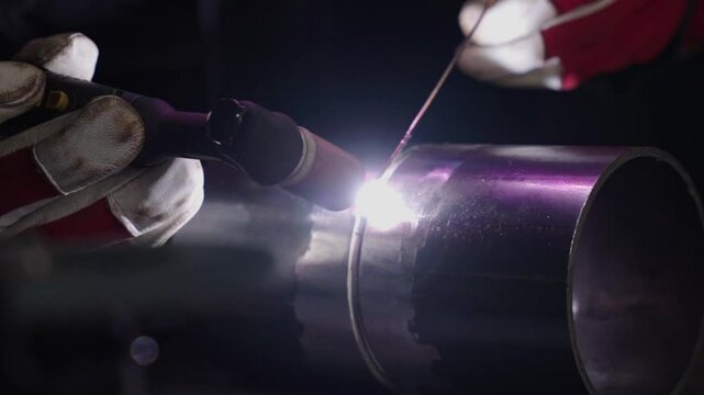 Precision TIG Welding A Skilled Artisan Joins Metal with Careful Technique. Experience the intricate process of melding pipes, showcasing craftsmanship and safety in high-definition clarity.