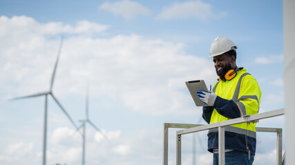 Service engineers checking system of windmill. Wind turbines generate electricity. Clean and Renewable energy concept.