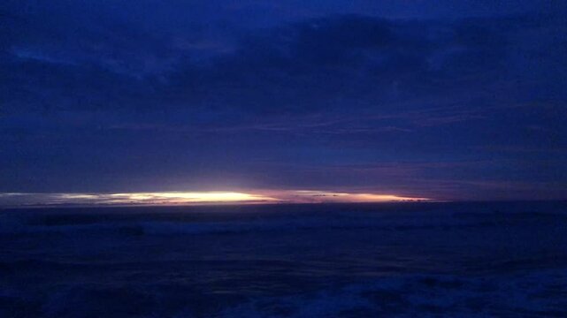 The sun sets over a calm beach, gentle waves wash over the shore. Golden times are on the horizon.