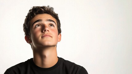 Obraz premium Young Man Looking Upwards with Hopeful Expression in Studio Light