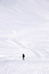 lonely man walking on snow covered caucasus mountain at georgia gudauri