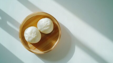 Fototapeta premium エレガントな白い背景に蒸しパン 2 個を空から撮影したミニマリストな画像