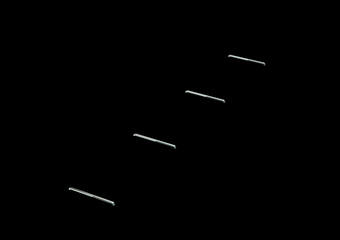 A Line Of Metallic Staple Pins Are Embedded In Black Background 3D Illustration