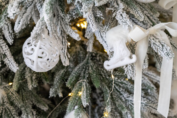 Christmas tree decorated with white balls, bows and lights. Close-up