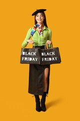 Stylish young woman with shopping bags on yellow background. Black Friday Sale