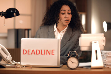 Stressed African-American businesswoman trying to meet deadline in office at night