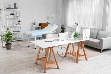 Interior of medical office with desks, couch and sofa