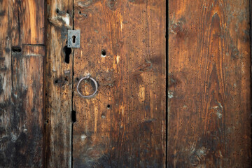 Vieille porte en bois vermoulu d'un chalet des Alpes suisse avec une serrure métalique