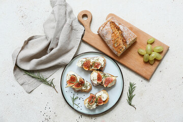 Plate of delicious fig bruschetta with ricotta cheese and rosemary on white background