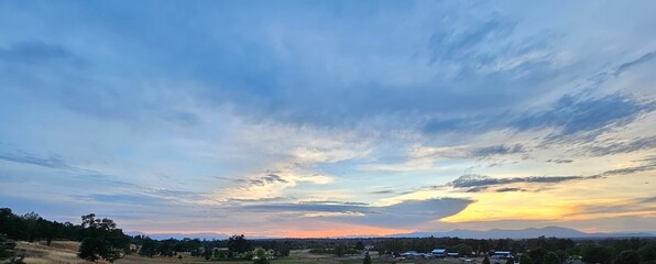 Blue, red, and yellow sky overlooking a green valley