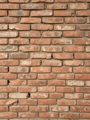 Fototapeta premium Old weathered brick wall with a rustic texture, perfect for background or design element, textured