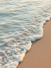 Rippling ocean wave with gentle foam reaching sandy coast, curl, nature