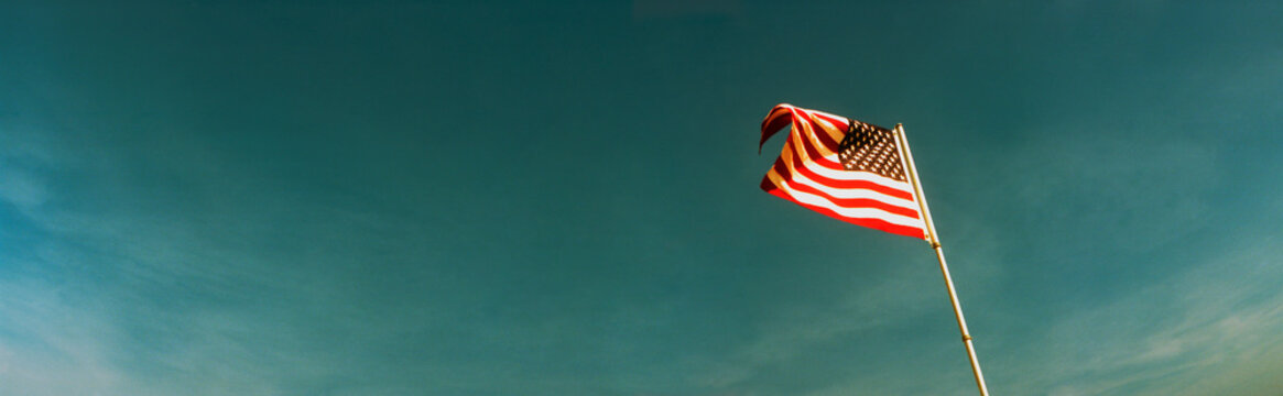 Panoramic image of an American Flag against a blue sky