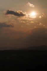 sonnen untergang wolken mit hügeln 