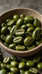 Close-up of green coffee beans in a bowl on concrete.