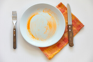 Empty plate isolated on white background with rustic cutlery set next to it
