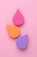 Colored Makeup Sponges on Pink Background