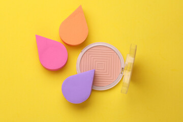 Colored Makeup Sponges and Powder Palette on yellow Background