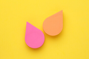 Colored Makeup Sponges on yellow Background