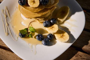 Delicious stack of pancakes with blueberries and banana slices