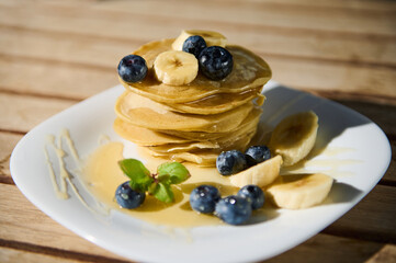 Delicious stack of pancakes with blueberries and bananas