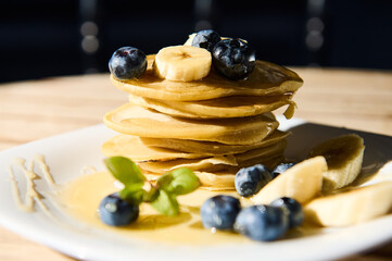 Delicious stack of pancakes with fresh blueberries and bananas