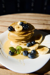 Delicious stack of pancakes with bananas and blueberries
