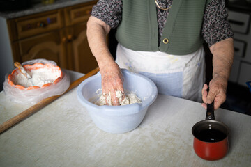Old woman kneading dough close up