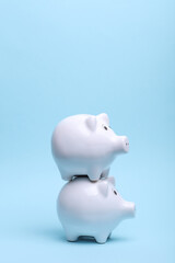 Ceramic white piggy banks on a blue background. Business concept. Conceptual photo