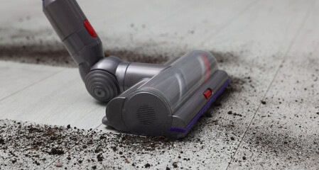 Cleaning floor with cordless vacuum cleaner indoors, closeup
