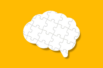 Brain shaped jigsaw puzzle on yellow background