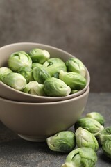 Fresh Brussels sprouts in bowl on grey table