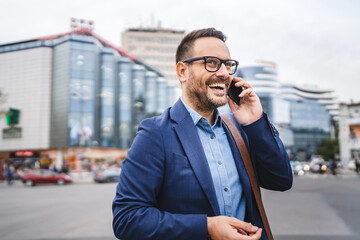 cheerful adult businessman talk on mobile phone while go to work