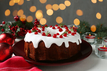 Traditional classic Christmas cake and decor on white table, closeup. Bokeh effect