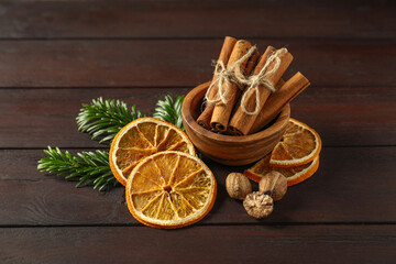 Different spices, dried orange slices and fir tree branches on wooden table. Christmas season