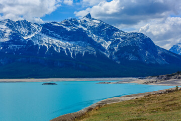 A mountain range with a blue lake in the foreground