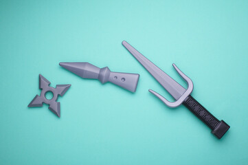 Children plastic toy ninja weapon on blue background. Top view © splitov27