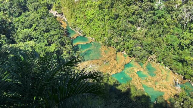 View looking down at blue pools of Semuc Champey from overlook in Guatemala