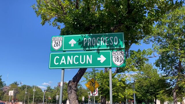 Street sign pointing towards Progreso and Cancun Mexico along highway