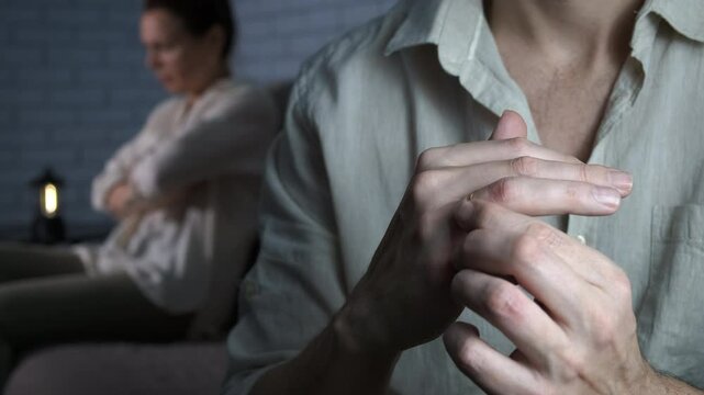 Man feel disappointed with golden ring. A man feel sad with golden ring in his hands by the depressed woman after conflict.