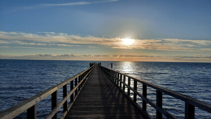 Fototapeta premium A long pier stretching out over the Pacific Ocean and reaching far into the horizon