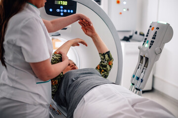 Medical nurse supporting patient during CT scan process.