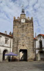 Clock tower and medieval gate in the city of Caminha, with the silhouette of a person passing by, Minho area located in the north of Portugal